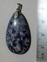 Front view of the lapis lazuli pendant next to a ruler showing a length over 4 cm.