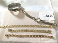 Overview of four bracelets and one watch on white background