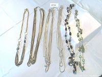 Full view of six costume jewellery necklaces laid on white background.