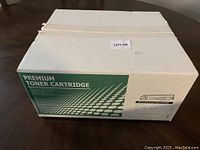 Closed cardboard box labeled Premium Toner Cartridge, unopened condition, lot tag attached.