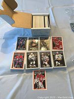 Photo showing the box of Topps 1995-96 hockey cards containing cards numbered 221 to 385 along with several cards laid out in front featuring various players in their team jerseys with distinct border styles.