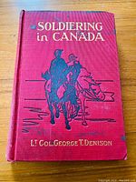 Front cover of the book showing the title, author, and illustration of soldier figures with red cloth background.