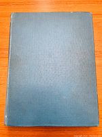 Front cover of the hardcover book showing blue textured cloth binding with minor wear.