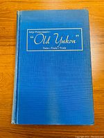 Front cover of Old Yukon Tales - Trails - Trials showing blue cloth hardcover with gold embossed title.