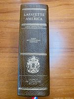 Spine of the leather-bound book showing title, author, edition, and publisher crest embossed in gold.