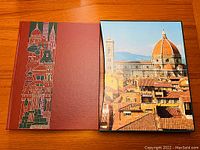 Book with decorated spine and cover next to photographic slipcase of cityscape with dome and tower.