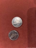 Two Canadian 1969 silver dollar coins on red cloth
