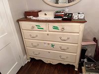 Front view of dresser showing five drawers, painted frame and stained wood top