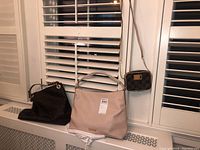 Image showing all three purses: two large Michael Kors totes on left and center, and small checkered crossbody on right hanging.