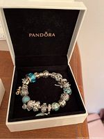 Bracelet arranged in Pandora box on wood surface