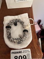 Bracelet on branded pouch with storage bag visible