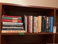 Shelf of hardcover non-fiction books showing titles and condition.