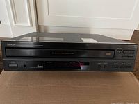 Front view of Denon DCM-260 compact disc player showing display, buttons, and branding.