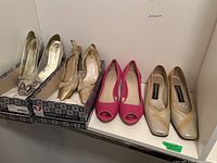 Four pairs of ladies shoes, including Roberto Capucci and Donald J Pliner brands in sizes 8.5-9, displayed on a table with some shoes on original boxes.