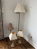 Photo showing the four lamps together: two matching table lamps, a table lamp with beaded shade, and a floor lamp.