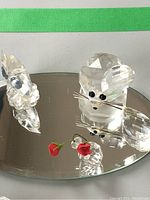 Glass miniature animals on beveled mirror tray including a mouse with detached ear, a rabbit, and red rose figurine.