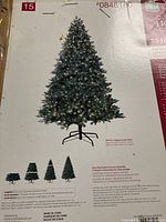 Box showing image of the 7.5 ft pre-lit artificial Christmas tree with details on metal stand and quick connect sections.