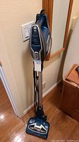 Full length view of the Shark Duo Clean Rocket vacuum standing upright with cord wrapped down length