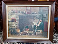 Full view of the framed vintage art print showing a man reading near a stone fireplace with his dog.