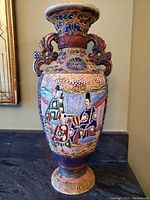 Front view of vintage Japanese Satsuma vase showing detailed raised enamel artwork depicting figures in traditional Japanese attire with colorful background.