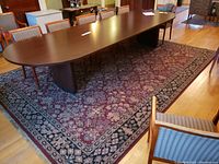 Large rectangular area rug under a conference table showing overall pattern and condition.