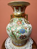 Front view of the vintage Occupied Japan ceramic vase showing detailed floral patterns and gold ring handles
