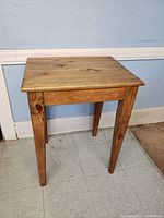 Full view of vintage solid wood end table showing natural wood grain and tapered legs.