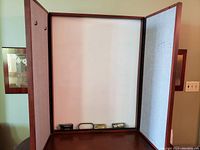 Fold out whiteboard cabinet with doors open showing the whiteboard center and fabric bulletin on the side panels with hooks.