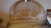 Front view of bamboo headboard showing curved top and sunburst pattern design