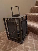 Front and side view of a rectangular wooden candle lantern with metal mesh side panels and a handle on top.