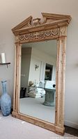 Full view of the large wood framed floor mirror reflecting a room interior