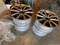 Four stacked BMW alloy tire rims with visible multi-spoke design and metallic finish seen from top and side angles