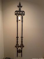 Full view of the tall cast iron decorative wall hanging mounted on wall