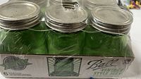 Photo showing six green Ball vintage style canning jars in original box with metal lids and seals, shrink wrapped and unopened.