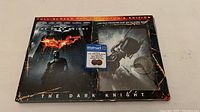 Front and back view of the Batman The Dark Knight DVD Collector's Edition sealed box showing artwork and promotional Walmart exclusive sticker for 2-in-1 DC comic book and Two-Face prop replica coin.
