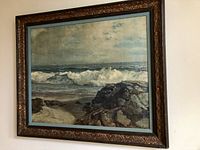 Full view of framed oil on canvas seascape painting showing ocean waves and rocky shore, with ornate wooden frame.