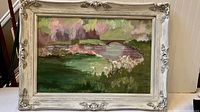 Full view of the framed oil painting showing landscape with bridge, river, and florals in pastel colors.