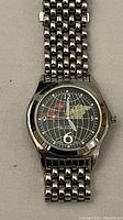 Front view of the Paul Jardin men's wrist watch showing the black dial with a world map design and numeric dial markers at 3, 6, 9, and 12.