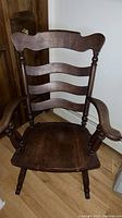 Front view of the vintage wooden rocking chair showing ladder-back detail and seat.