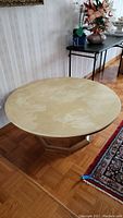Round stone top table showing the smooth beige stone surface and its round shape with natural stone patterns.