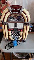 Front view of the miniature tabletop jukebox showing overall design and color scheme.