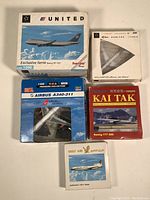 Five commercial airline model boxes including United Boeing 747, Airbus A340 Lufthansa, Airbus A340 Virgin Atlantic, Kai Tak Boeing 777, Gulf Air Lockheed L-1021.