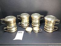 Full set of 4 silver plated and glass individual French presses plus creamer and sugar bowl shown from front.
