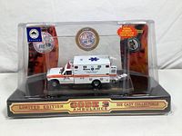 Front and side view of Code 3 Boston EMS Limited Edition ambulance scale model packaged in original display case with serial number certificate.