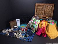 Woven box with colorful silk scarves, necklaces, small black evening bag, and small jewelry box
