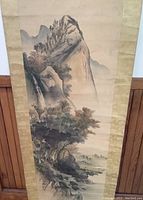 Close-up of the watercolor scroll showing the mountainous landscape with a waterfall and detailed foliage.