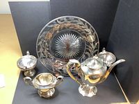 Overview of glass plate and four sterling silver pieces
