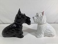 Side view of black and white terrier liquor decanters showing profiles and shapes.