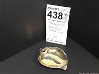 Photo showing the Tiffany & Co. trinket dish with MaxSold lot tag indicating Tiffany & Co. Heart Leaf Trinket Dish, one piece.