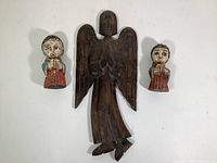 Photo showing three vintage carved wood angels: one large dark brown angel with praying hands, and two smaller hand-painted angels playing instruments, arranged on a white background.